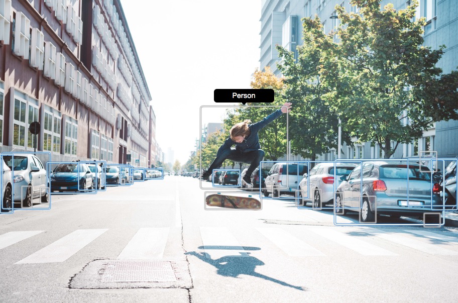 Person, die auf einer Stadtstraße einen Skateboard-Stunt zwischen geparkten Autos macht.