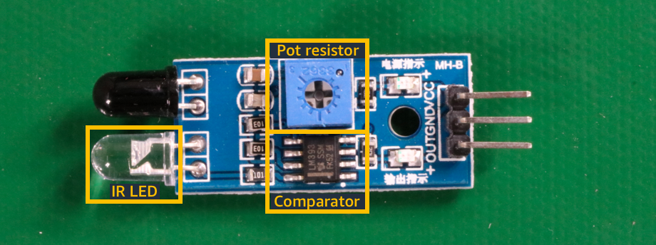 Imagen de componentes que muestra un LED IR, un resistor de potencia y un chip comparador en una placa de circuito.