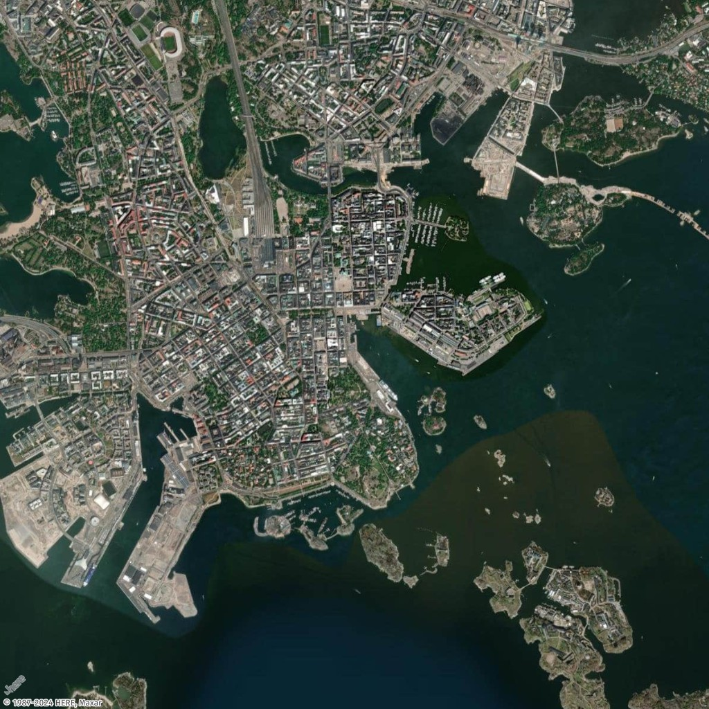 Aerial view of a coastal city with dense urban areas, harbors, and surrounding islands.