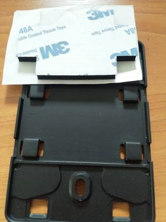 Black plastic mounting bracket with adhesive tape strip for secure installation.